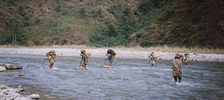 Trekking Porters fording the Piluwa Khola in the Arun Valley